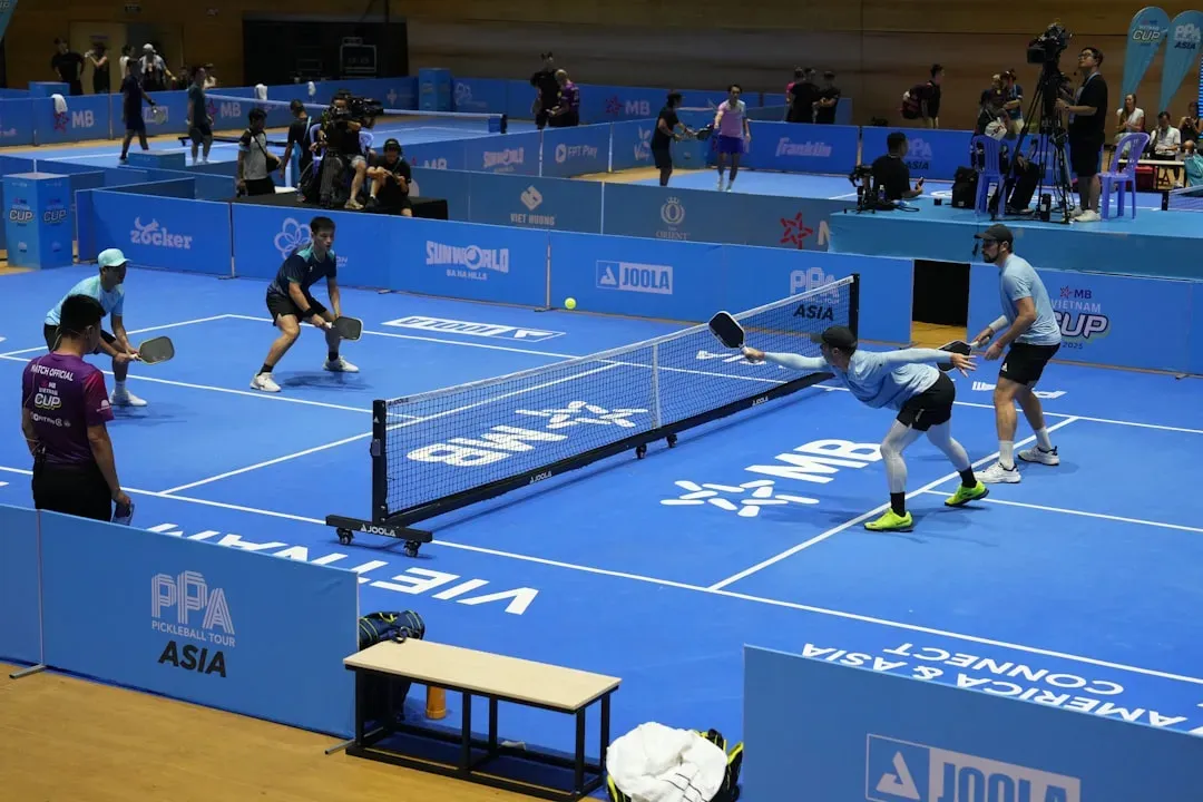 Players competing in an active pickleball doubles match at a professional indoor tournament