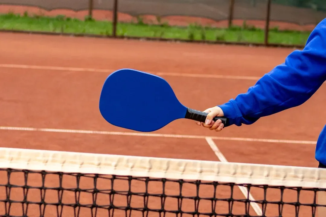 Older adult practicing pickleball technique with ball machine for solo training and skill development