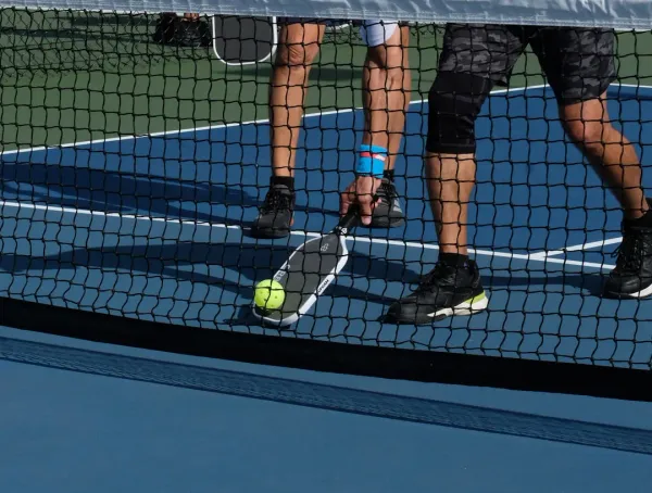 Overhead view comparing pickleball and tennis shoe sole tread patterns and design differences on court surface